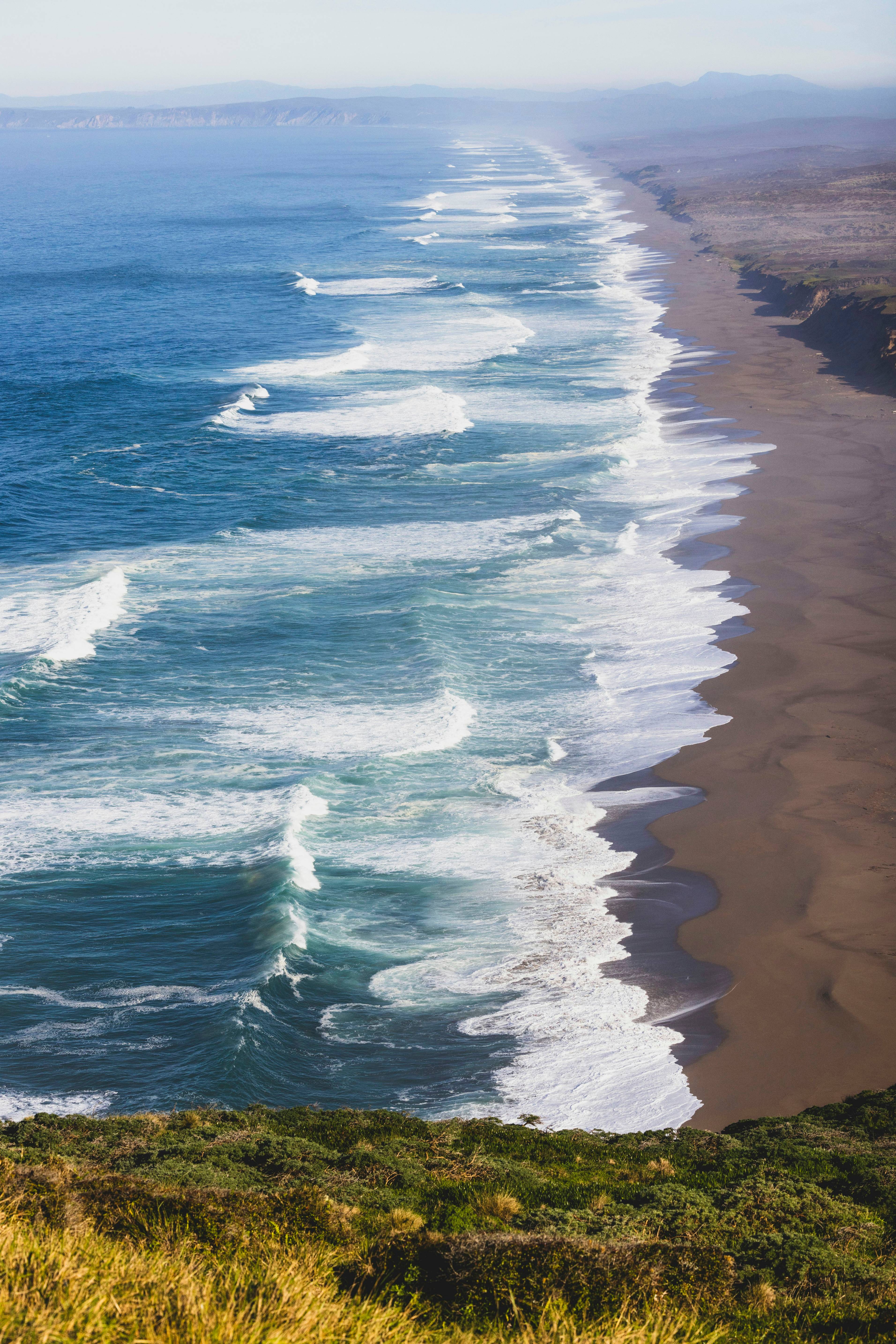 a view of the ocean from the top of a hill