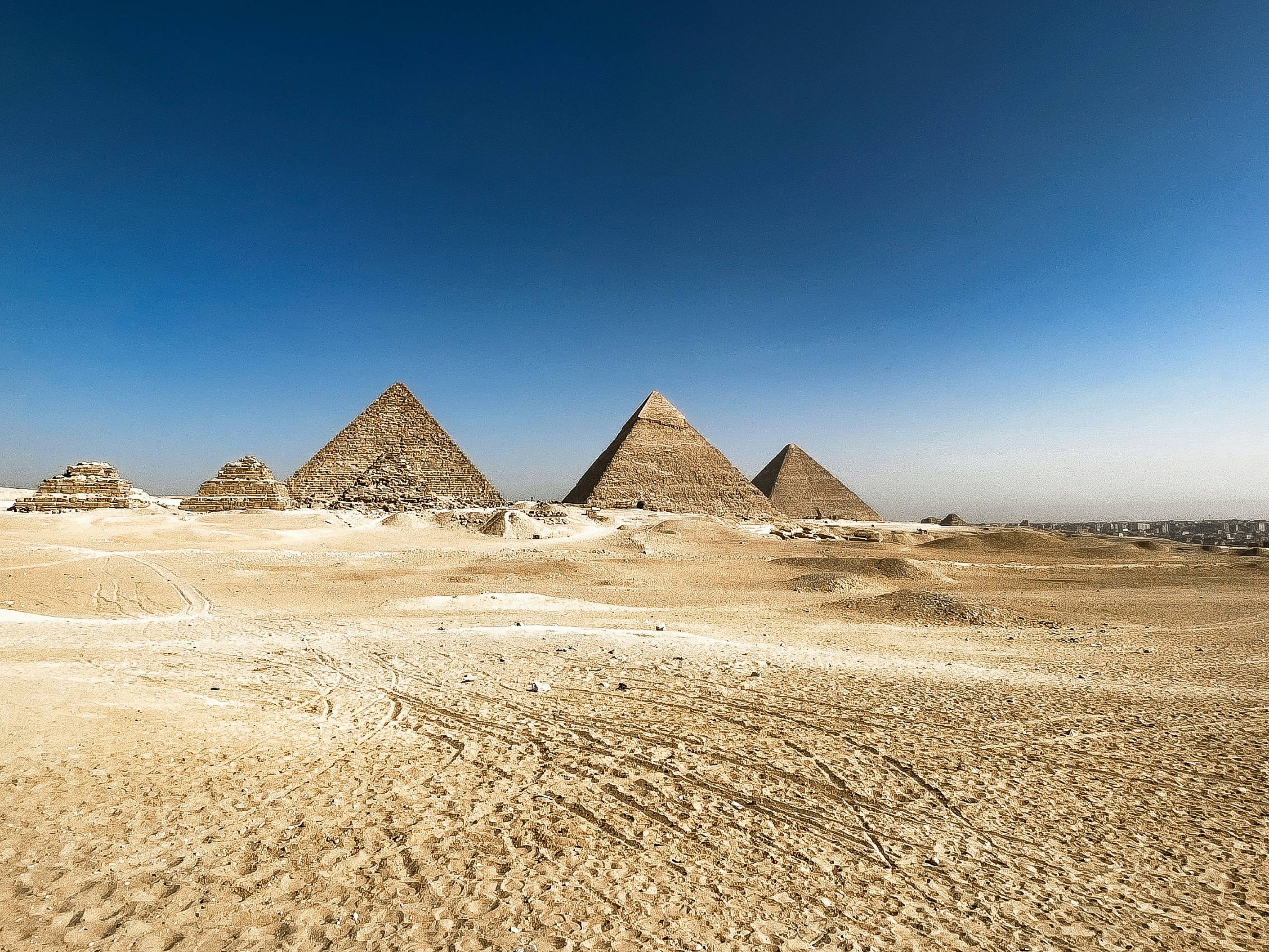 Pyramids of giza stand tall in the desert.