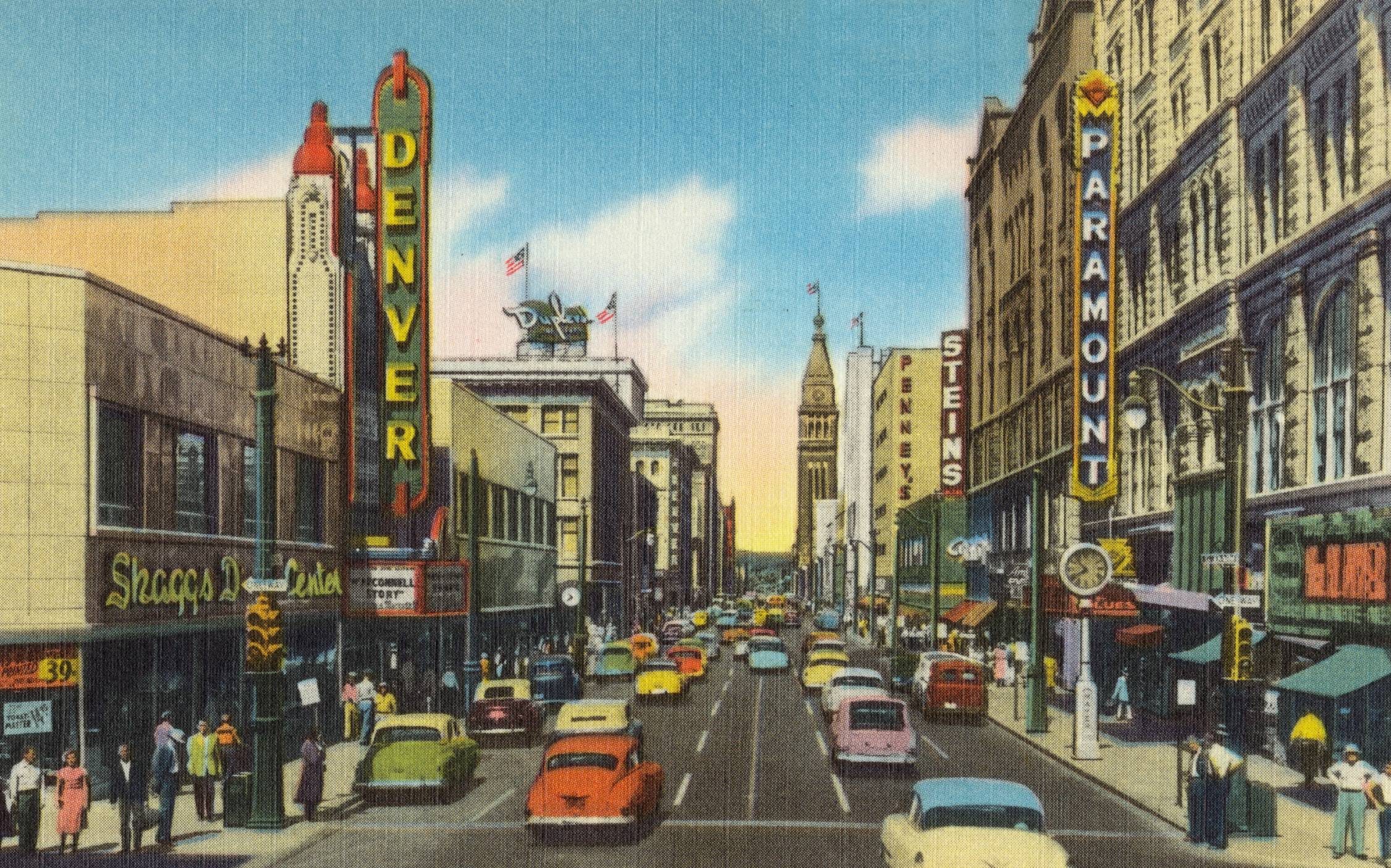 cars on road between high rise buildings during daytime