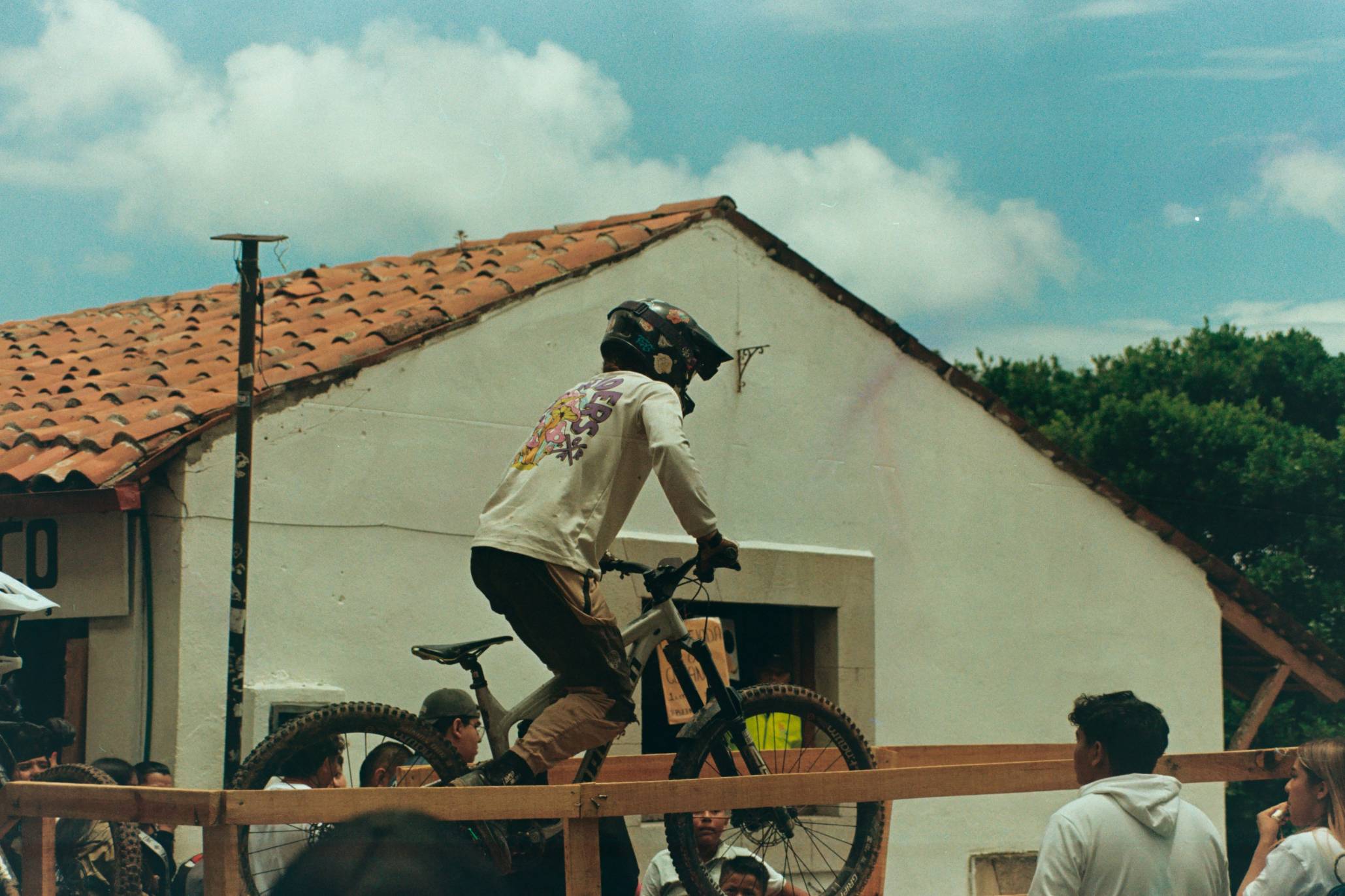Mountain biker jumps over a wooden barrier